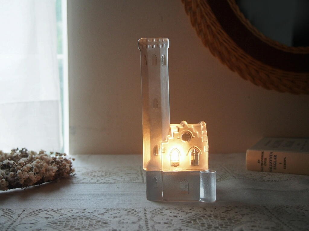 Nybro Glasbrukによる教会モチーフのクリスタルガラスキャンドルホルダー。灯りをともすと塔の窓からやわらかな光がこぼれ、静かな時間を包み込む様子 antenna