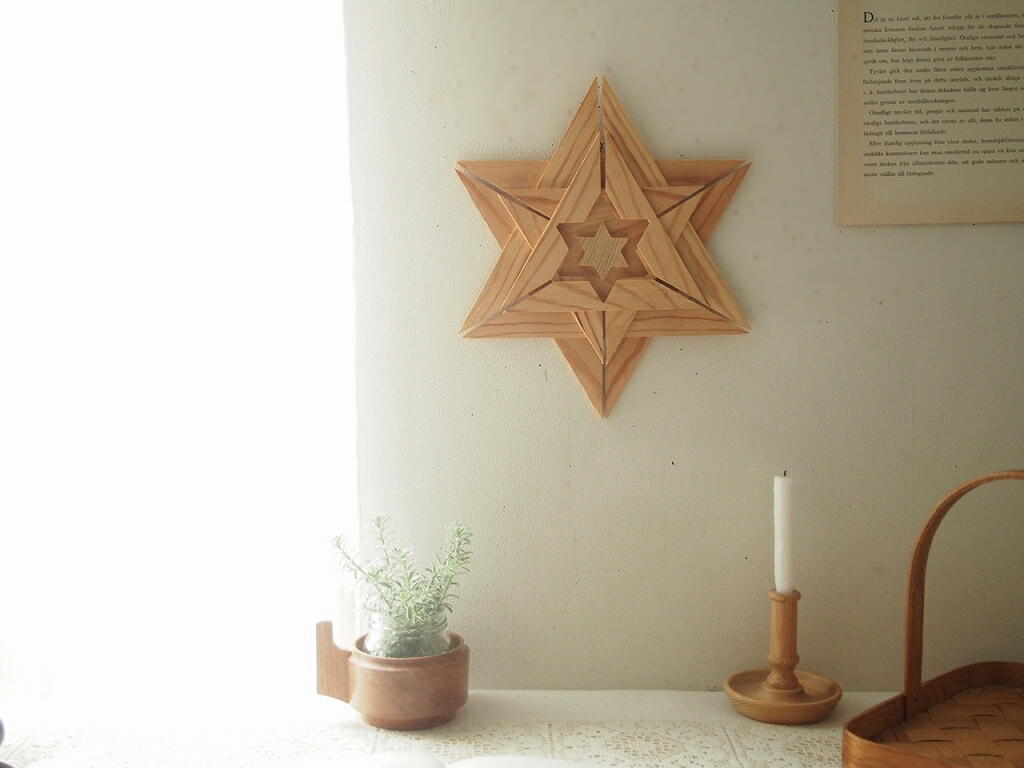 木製スターオーナメントを壁に飾った北欧インテリア。自然光の入る窓辺にあたたかな空気感