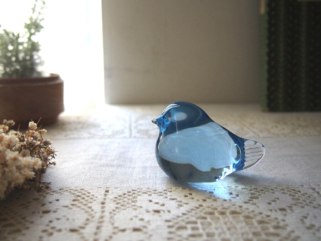 スウェーデン製の青いガラスの小鳥。レースのクロスの上で光を受けて透ける北欧ヴィンテージオブジェ。 antenna