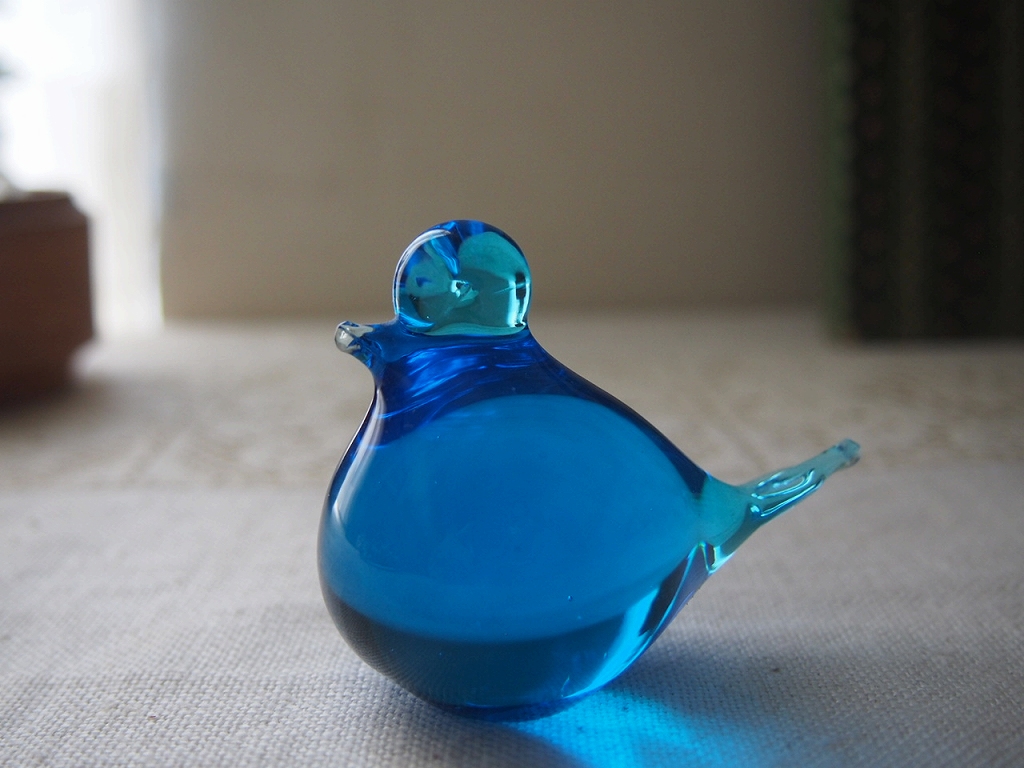 艶のある表面に光が映るガラスの青い小鳥。手仕事のガラスならではの厚みとゆらぎが感じられる。 antenna