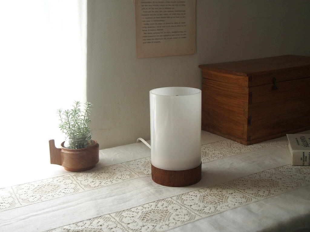 テーブルに置いたスウェーデン製テーブルランプ。樹脂シェードとチーク無垢材ベースの北欧らしい灯りの風景。 antenna