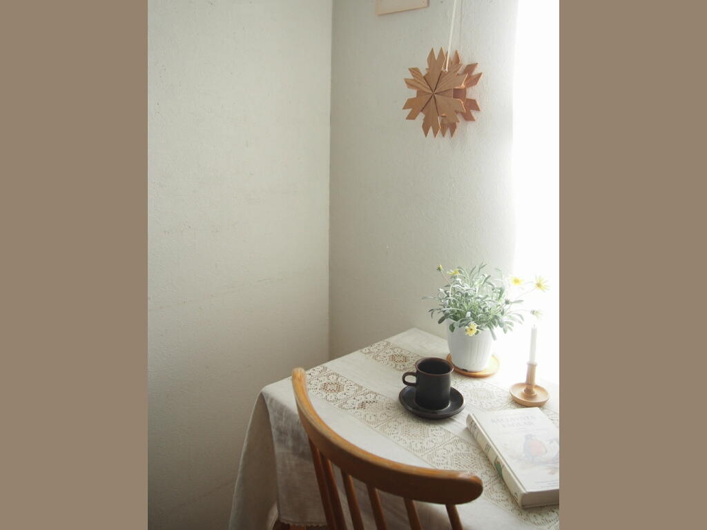 木板を重ねて作られた立体的な北欧オーナメントが白壁に掛けられた、自然素材の装飾。 antenna