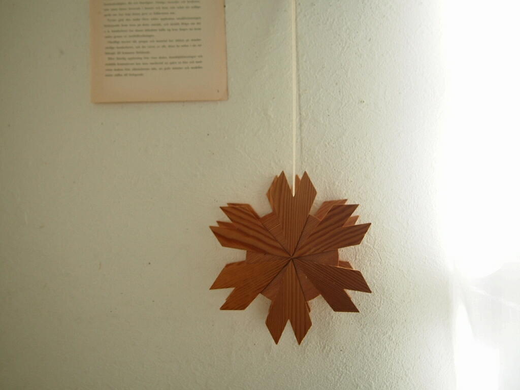 スウェーデン製の木製オーナメント。板を重ねた立体的なデザインが壁に飾られている様子。 antenna