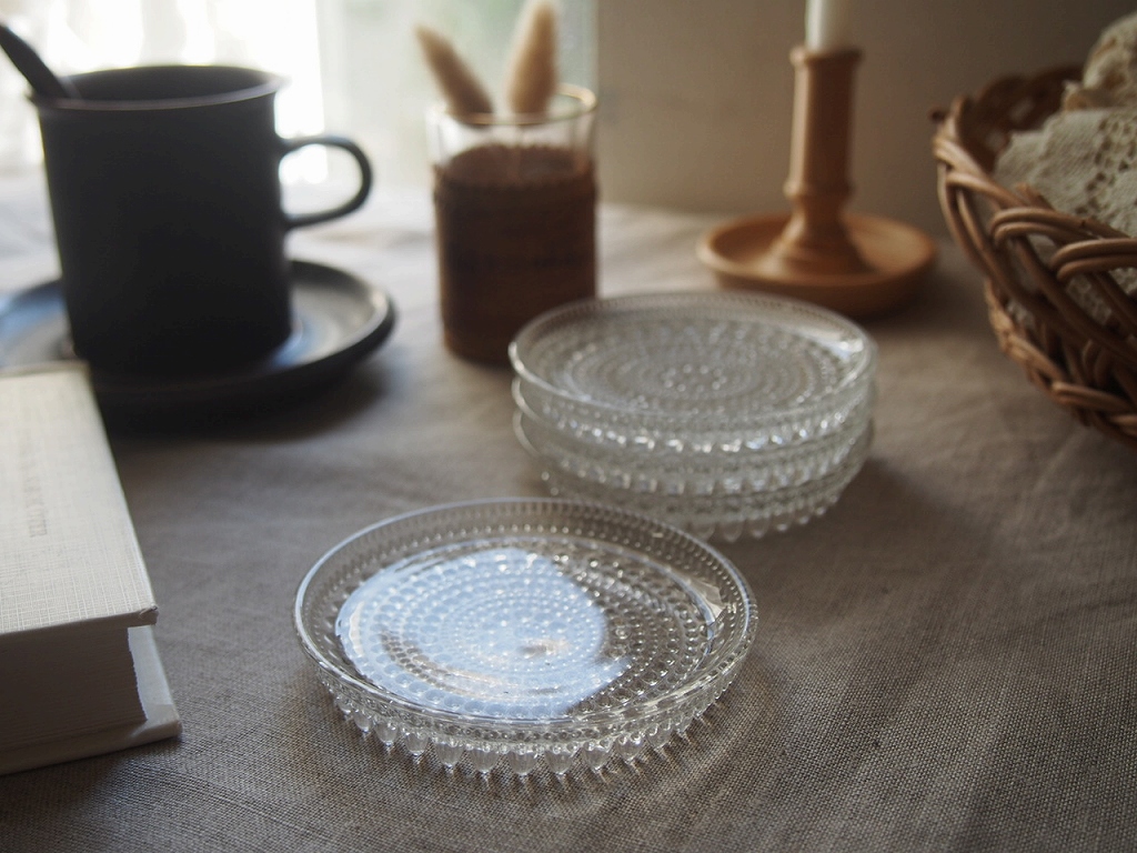 窓辺の光の中で重ねて置かれたカステヘルミのコースター。 antenna