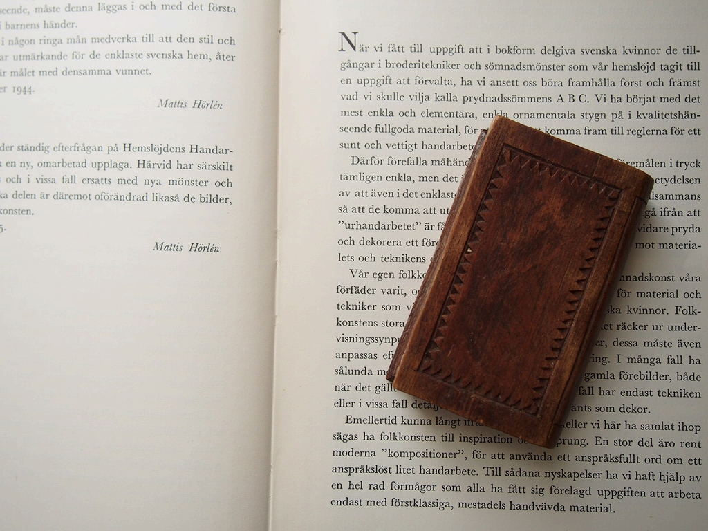 木製の本型小物入れを古い洋書の上に置いた上からのカット。 antenna