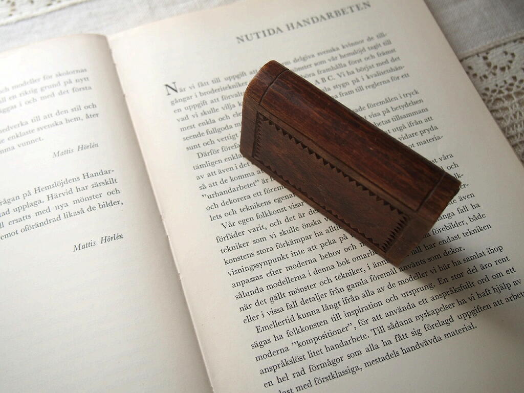 本の形をしたスウェーデン製木製小物入れを開いた本の上に置いた様子。 antenna